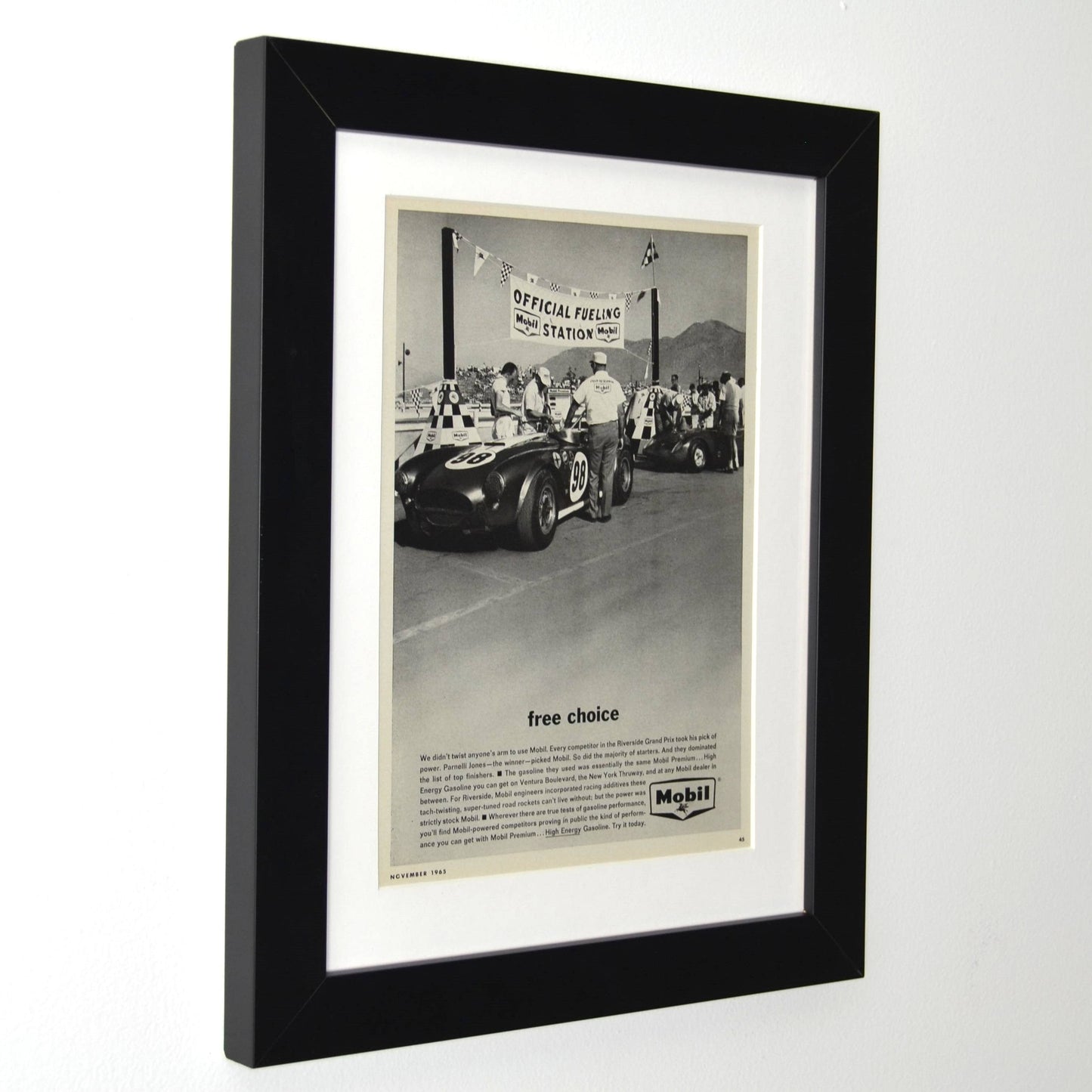 Framed side view of 1965 Mobil vintage print ad featuring Shelby Cobra No. 98 at the Riverside Grand Prix fueling station. Driven by Ken Miles, Bob Bondurant, and Parnelli Jones.