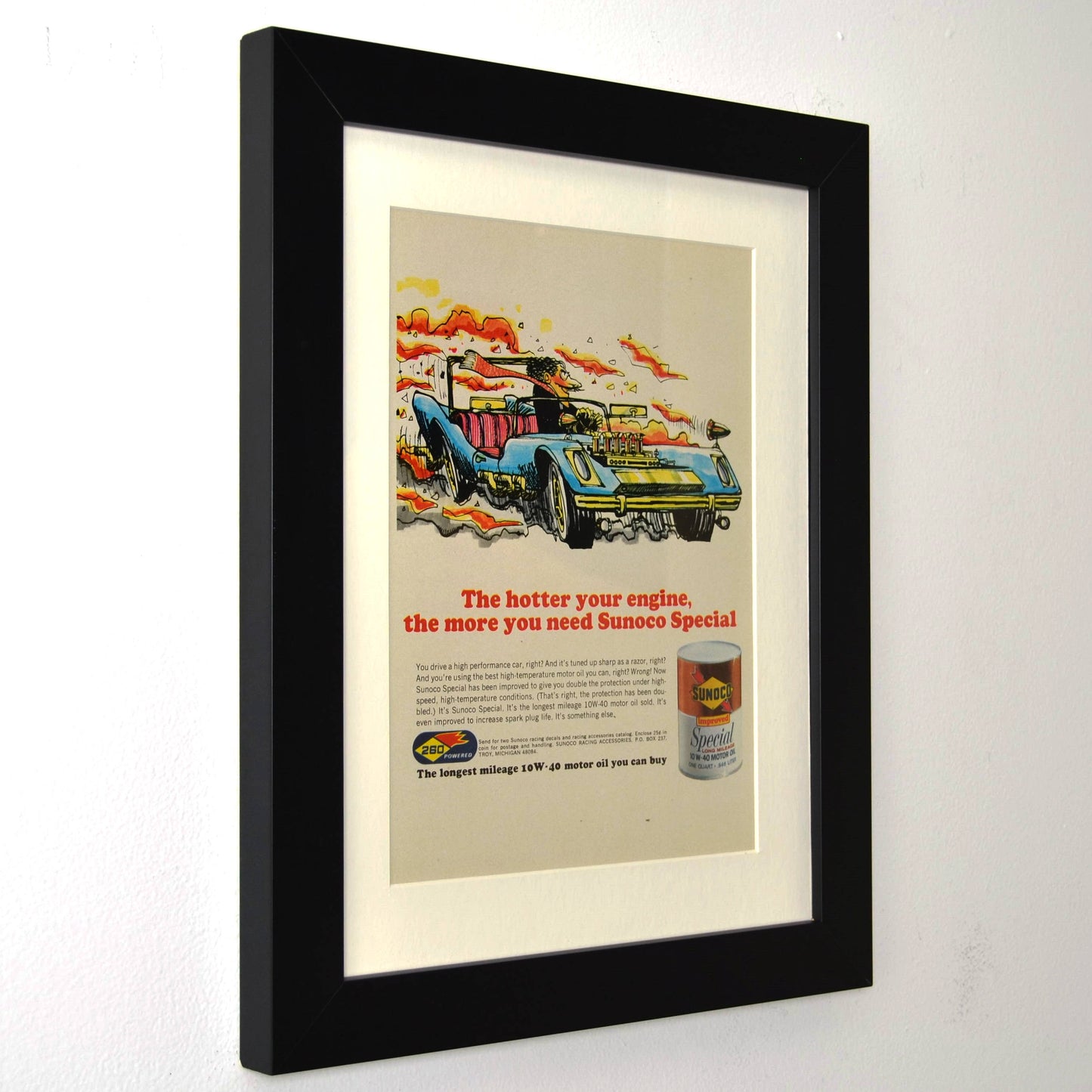 Framed vintage 1967 Sunoco Special oil print ad featuring a bold racing illustration with a high-performance car. Professionally dry mounted and displayed in a 10x13 matte black frame with white matting, showcasing Sunoco branding side view