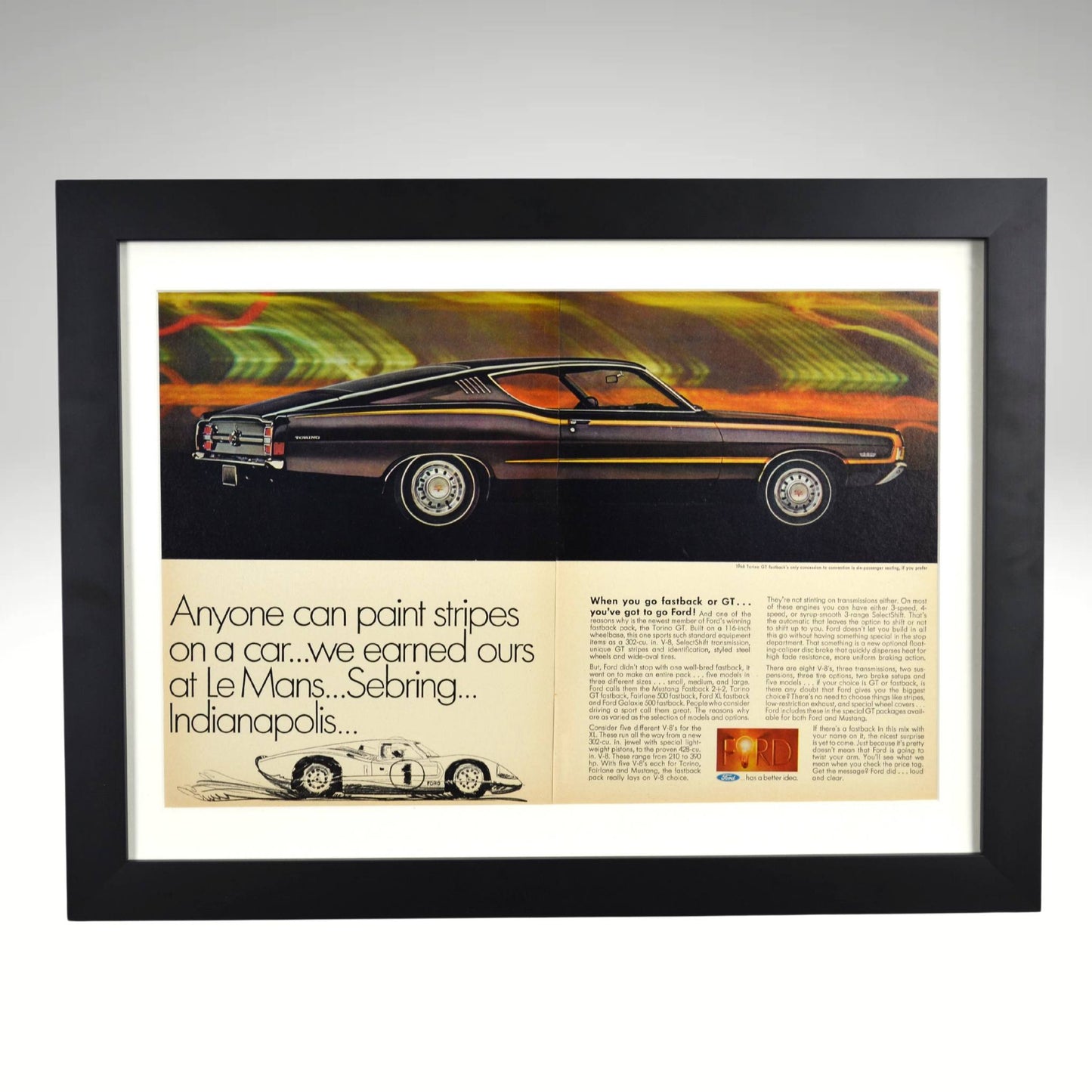 Framed 1968 Ford Torino GT Fastback print ad featuring the sleek muscle car and a nod to Ford’s GT-40 racing legacy at Le Mans, Sebring, and Indianapolis.
