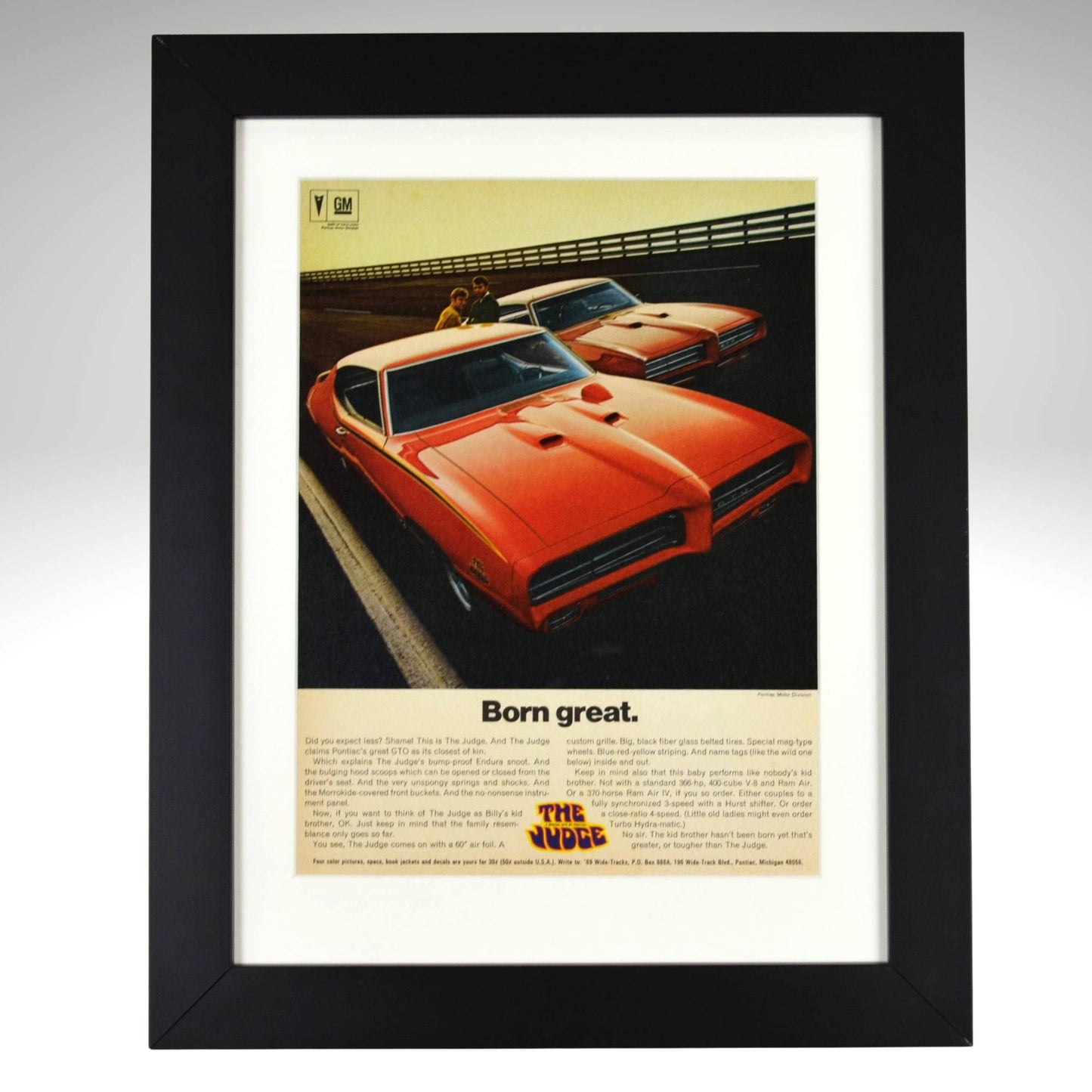 Framed 1969 Pontiac GTO Judge vintage print ad featuring two Carousel Red GTOs with headline “Born Great.” Displayed in a matte black frame with white mat — classic muscle car wall art for collectors and enthusiasts.