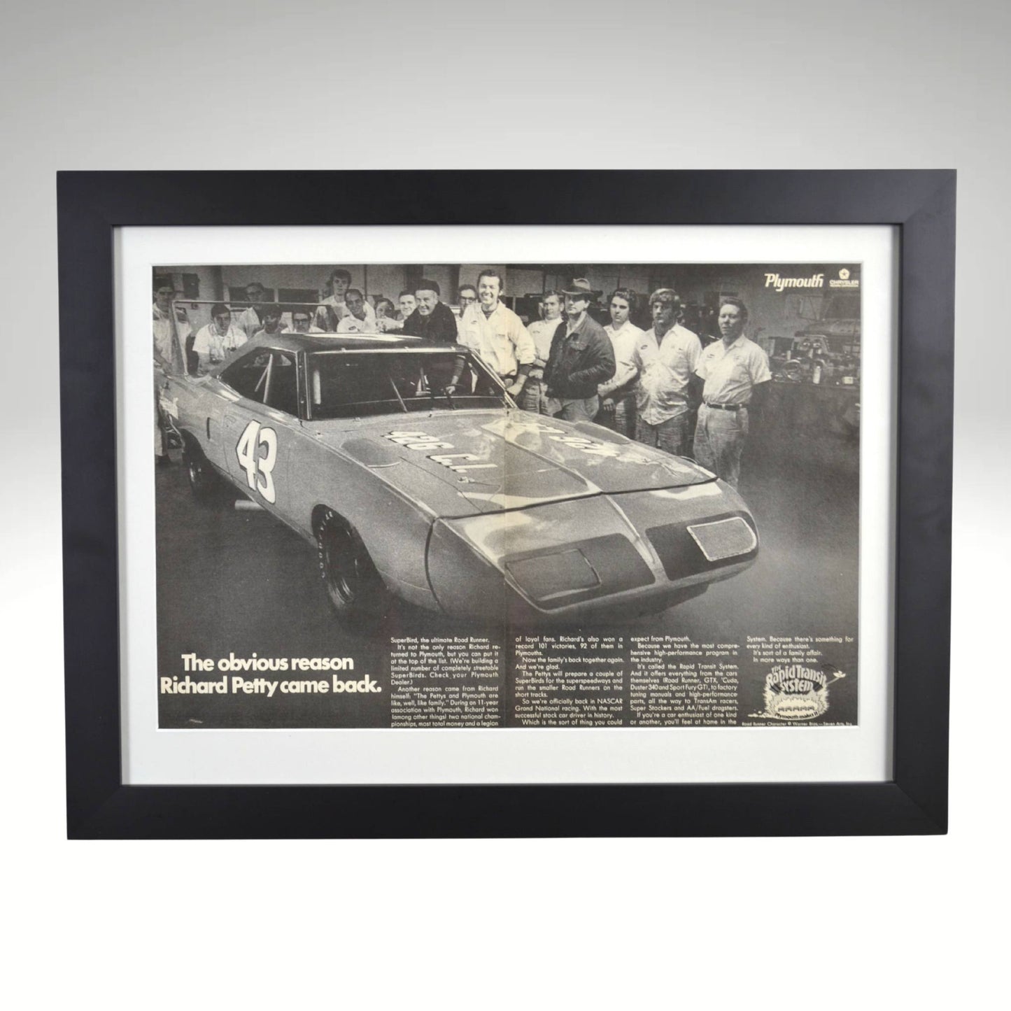 Framed 1970 Richard Petty Plymouth Superbird black and white print featuring the legendary NASCAR driver’s return to Plymouth, displayed in a black frame with glass front.