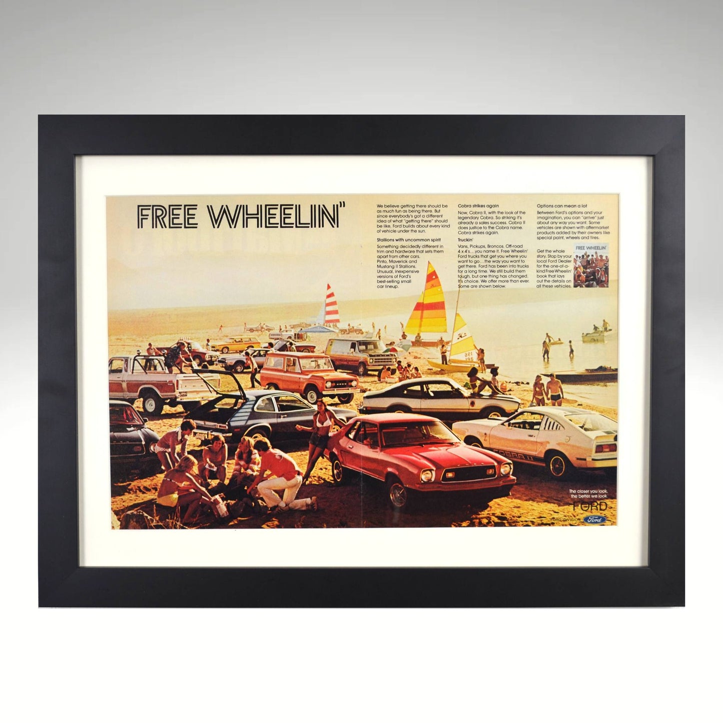 1970s Ford "Free Wheelin’" vintage print ad featuring classic Mustangs, Broncos, and custom vans in a retro beach scene.