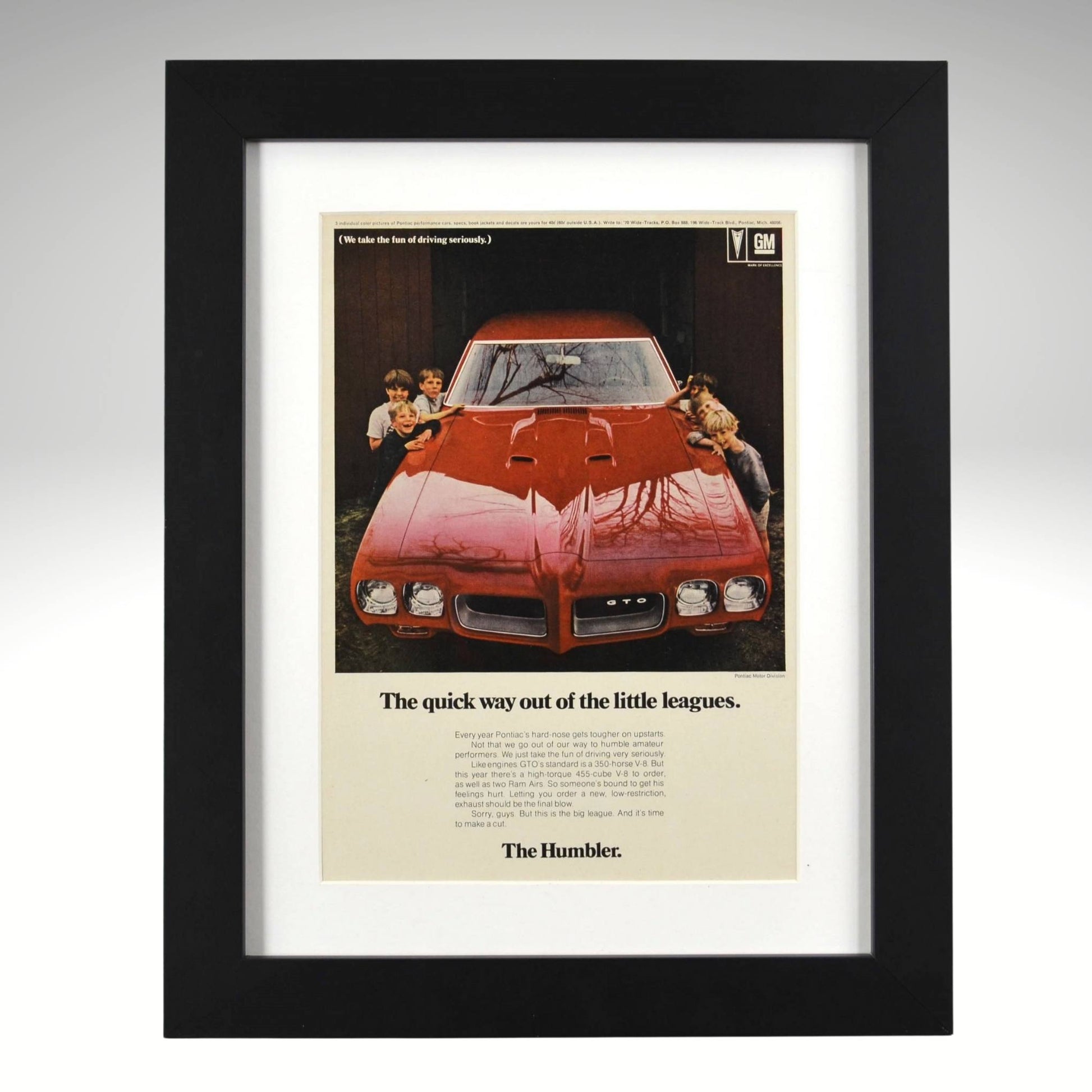 Framed 1970 Pontiac GTO Humbler ad – vintage print showing red GTO in garage with kids, tagline “The quick way out of the little leagues.”