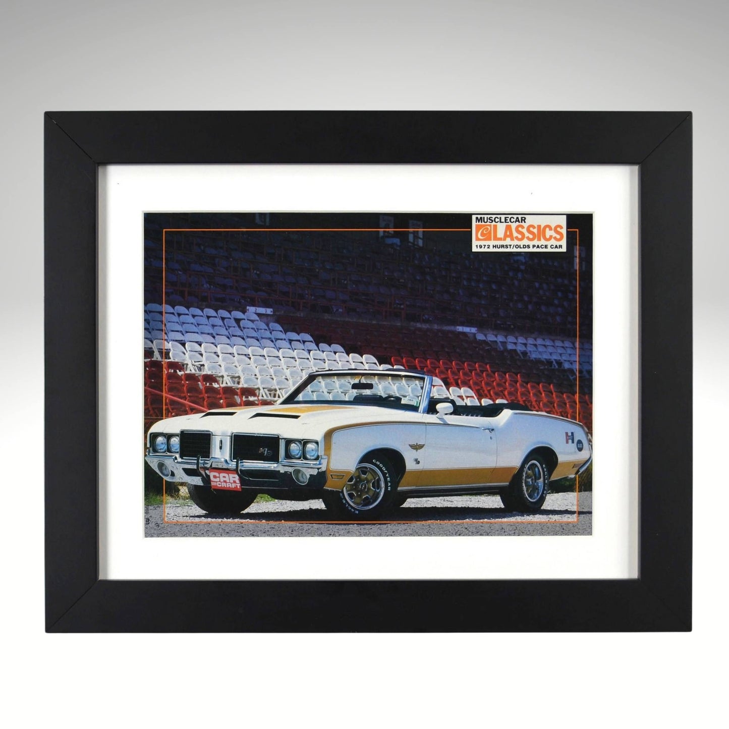 Framed 1972 Hurst/Olds pace car print – white and gold convertible parked at racetrack with grandstands in background.