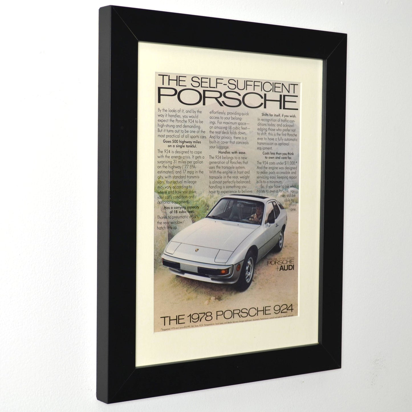 Framed vintage 1978 Porsche 924 print ad featuring silver 924 and retro text layout, dry-mounted and matted in black frame, ready for display side view.