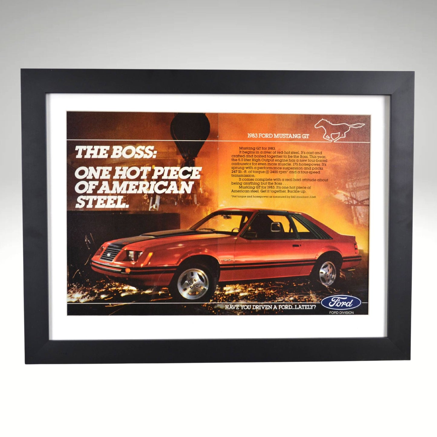1983 Ford Mustang GT framed print ad featuring the Fox Body design, 5.0L HO V8, and bold industrial backdrop.