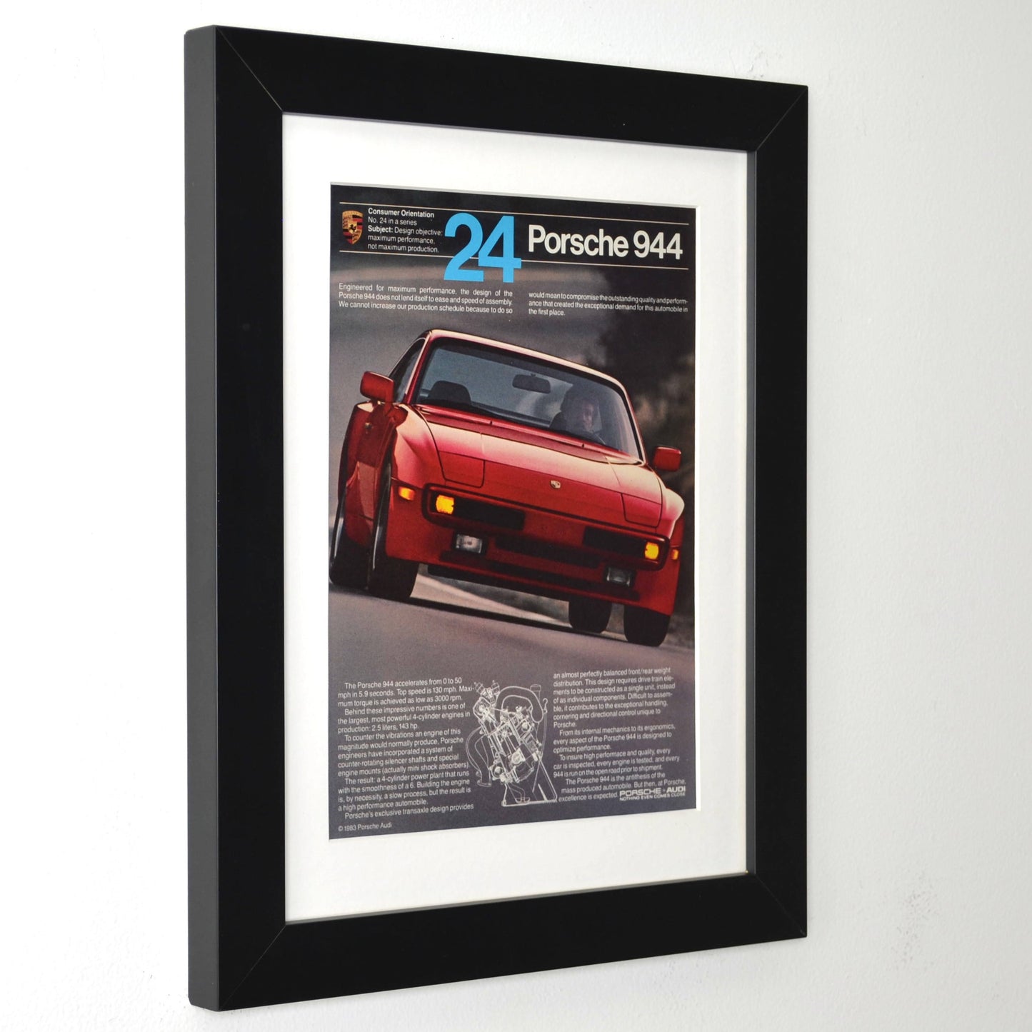 Framed 1983 Porsche 944 print ad with red 944 and cutaway diagram – vintage automotive wall art with new frame, mat, and glass side view.