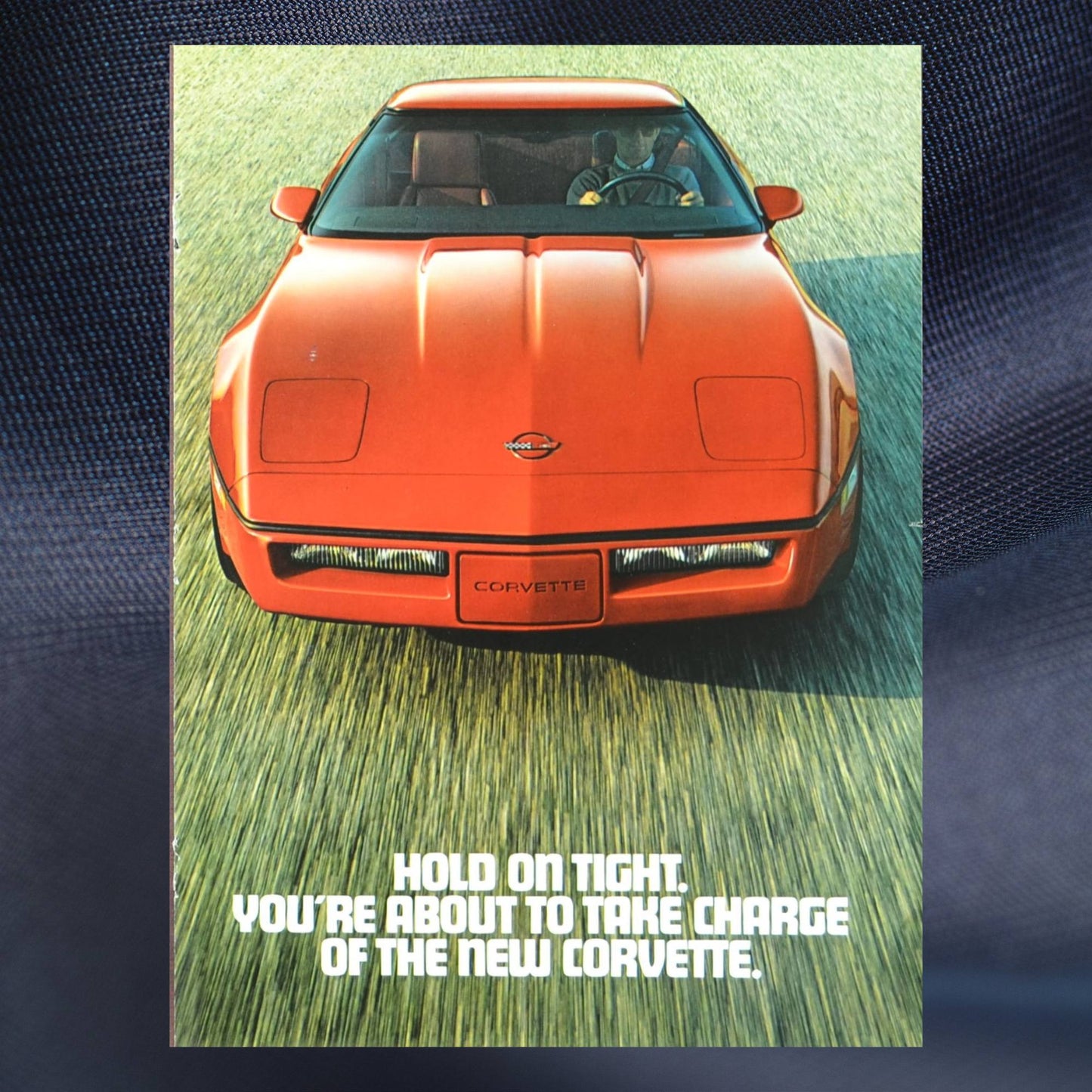 1984 Corvette ad cover – red C4 Chevy with bold “Hold On Tight” tagline from vintage magazine insert