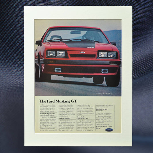 1985 Ford Mustang GT vintage print ad featuring the iconic Foxbody Mustang in red. Classic muscle car advertisement, perfect for garage decor and Mustang collectors.