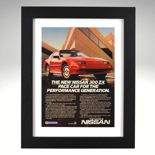 Framed 1986 Nissan 300ZX vintage print ad featuring a red 300ZX with geometric architecture and “For the Performance Generation” headline — authentic JDM wall art for collectors and enthusiasts.