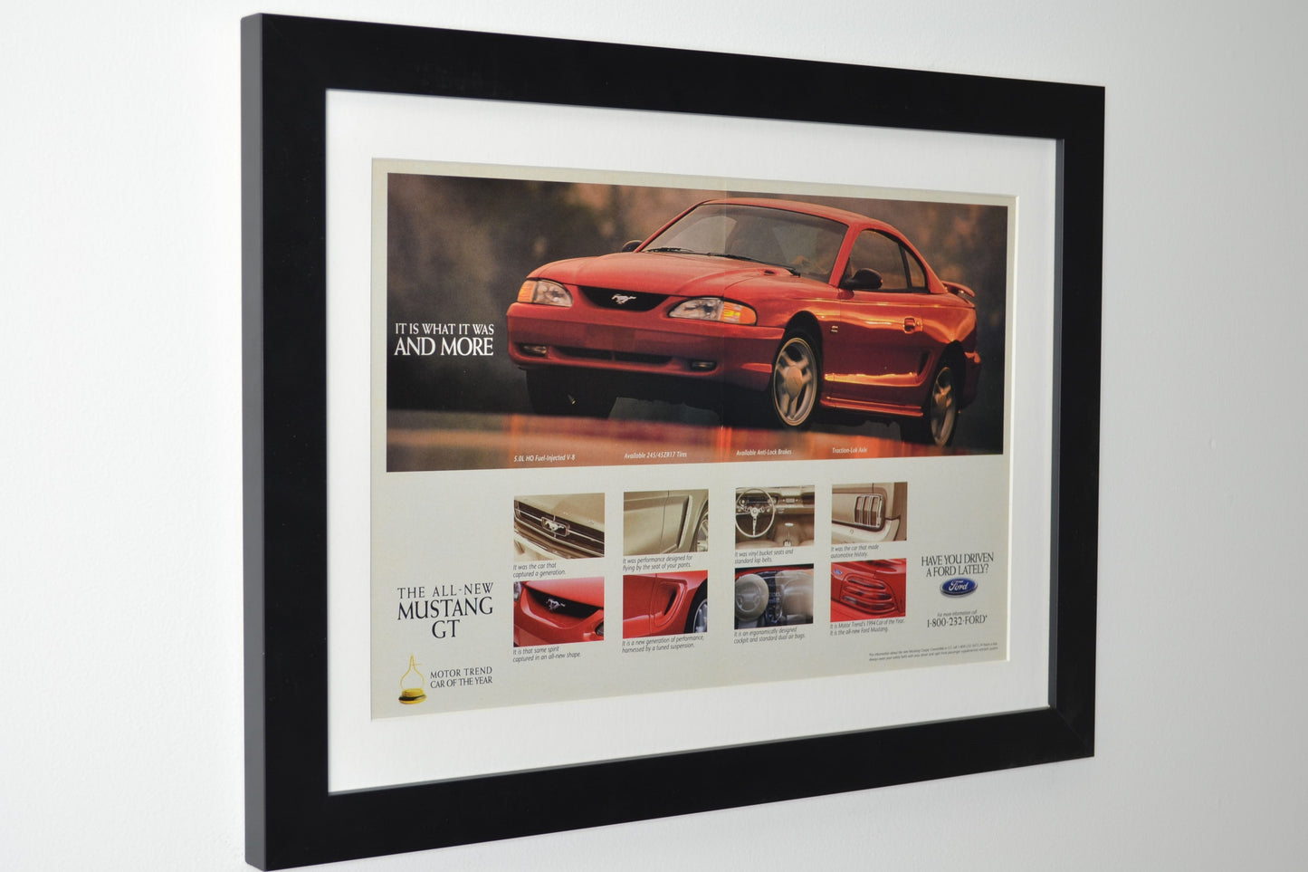 Framed vintage 1994 Ford Mustang GT print ad featuring the SN95 Mustang, Motor Trend Car of the Year award, and performance details. Professionally dry mounted and displayed in a 15x20 matte black frame with white matting side view