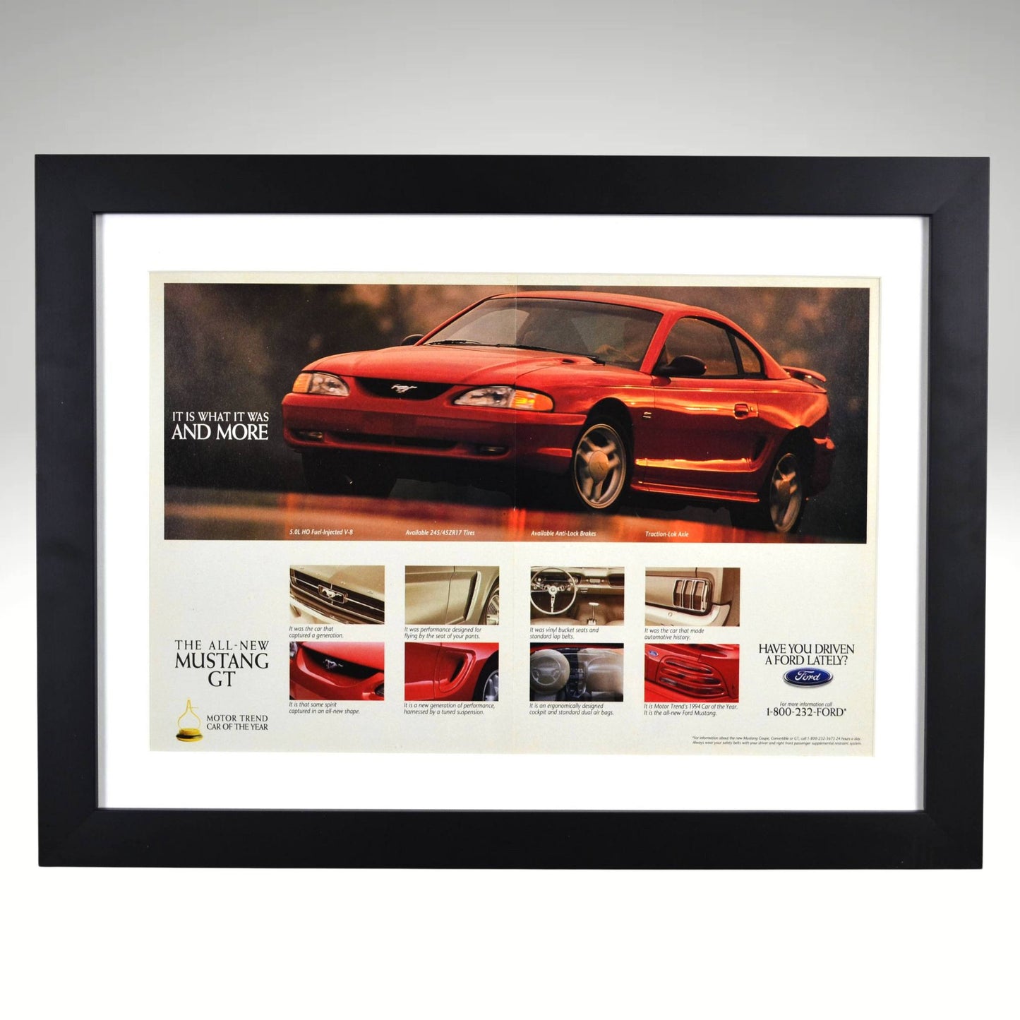 Framed vintage 1994 Ford Mustang GT print ad featuring the SN95 Mustang, Motor Trend Car of the Year award, and performance details. Professionally dry mounted and displayed in a 15x20 matte black frame with white matting.
