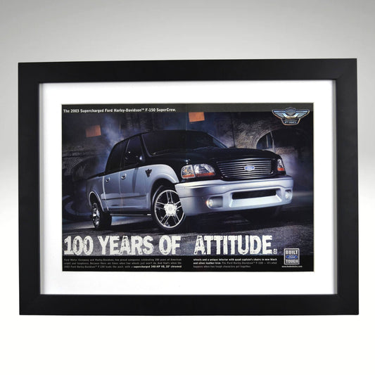 Framed vintage 2003 Ford Harley-Davidson F-150 print ad featuring a black and silver SuperCrew pickup with Harley-Davidson badging. Professionally dry mounted and displayed in a 15x20 matte black frame with white matting.1