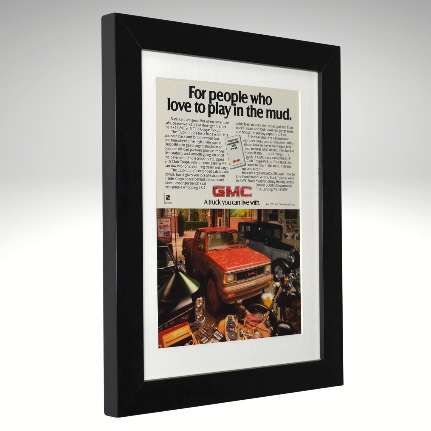 Framed advertisement for GMC truck with text 'For people who love to play in the mud.'