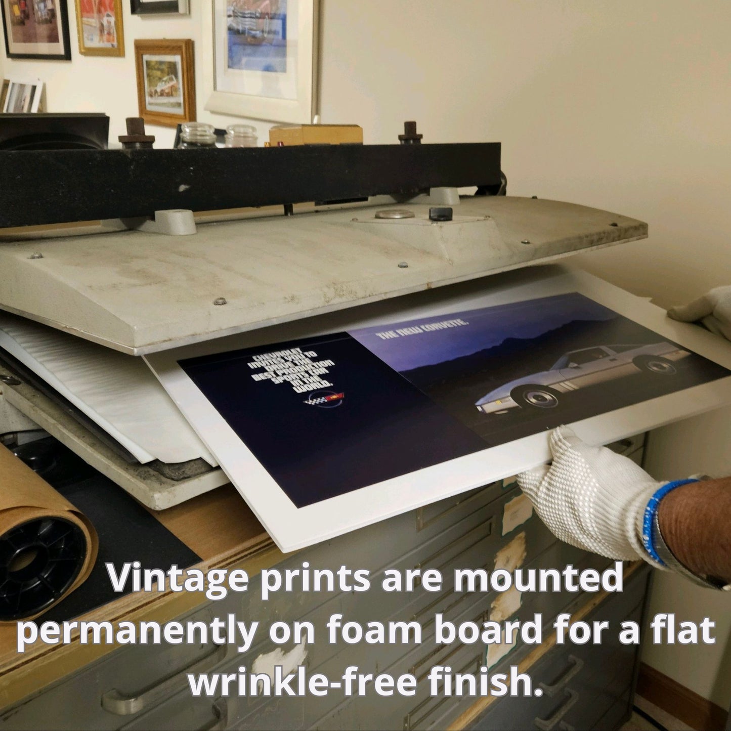Vintage automotive print being permanently dry-mounted on foam board, ensuring smooth, wrinkle-free finish at Vintage Art Garage