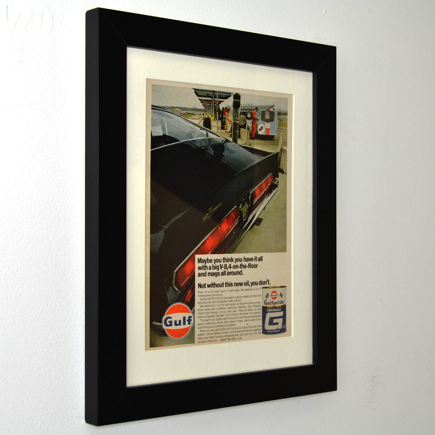 Framed vintage 1967 Gulf Oil print ad featuring a Shelby GT500 Mustang at a Gulf gas station. Professionally dry mounted and displayed in a 10x13 matte black frame with white matting, showcasing Gulfpride Formula G motor oil branding side view