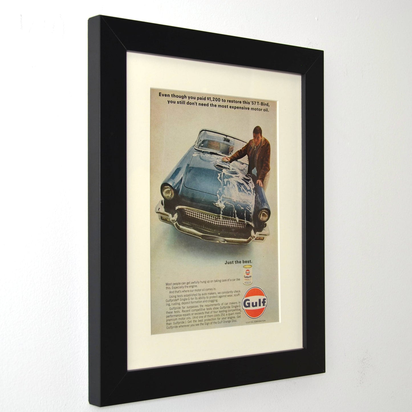 Framed vintage Gulf Oil print ad featuring a 1957 Ford Thunderbird. Professionally dry mounted and displayed in a 10x13 matte black frame with white matting, showcasing Gulfpride motor oil branding and a classic T-Bird restoration theme side view