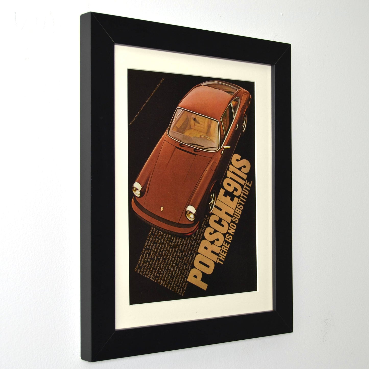 Framed vintage Porsche 911S print ad featuring the classic air-cooled sports car. Professionally dry mounted and displayed in a 10x13 matte black frame with white matting, ready for wall display side view