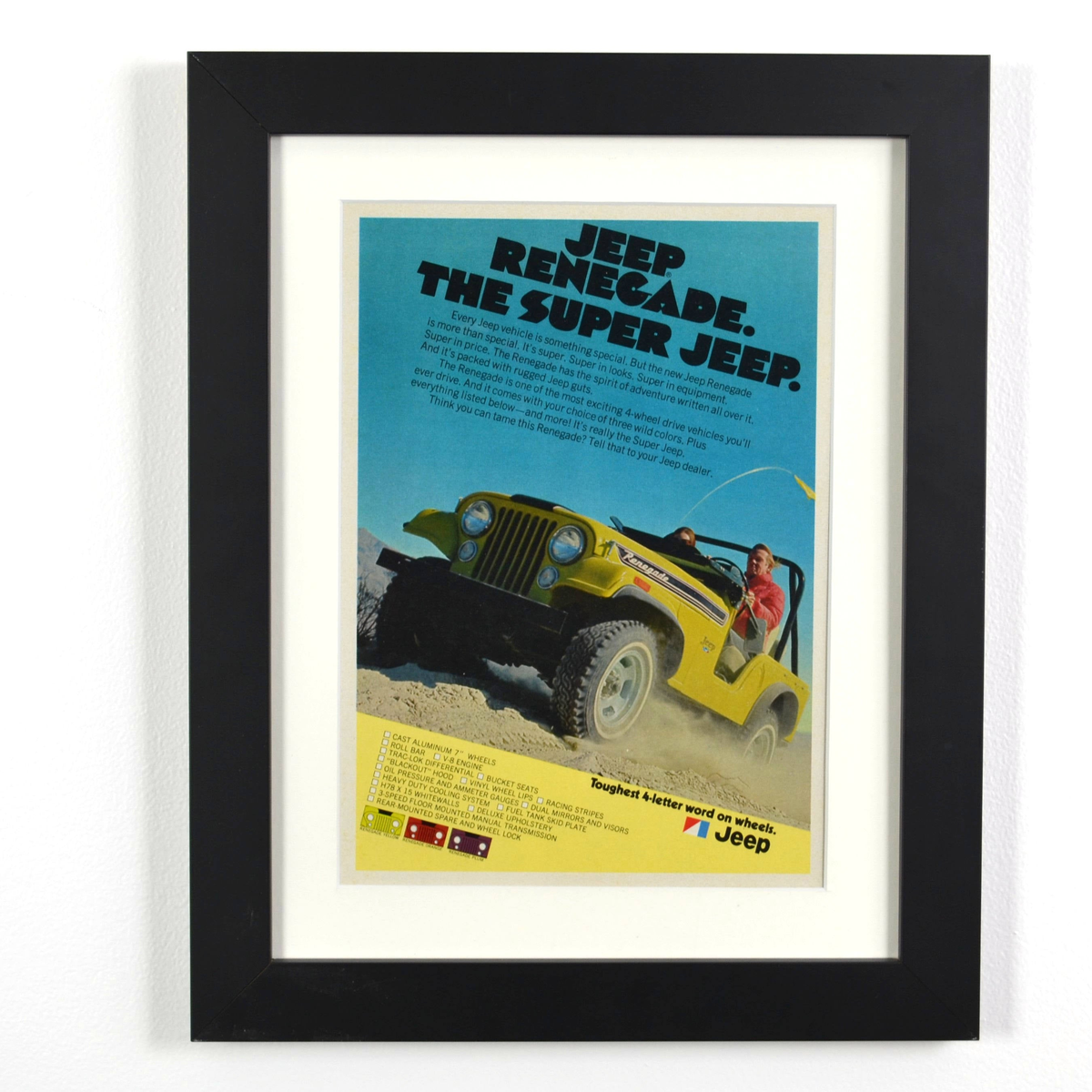 Framed vintage Jeep CJ Renegade advertisement featuring a bright yellow off-road Jeep in desert terrain. A must-have for classic Jeep enthusiasts and collectors
