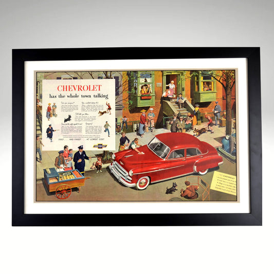 1950 Chevrolet Vintage Automotive Artwork – Framed 18x25 Classic Car Ad featuring a nostalgic city scene with a red Chevy, professionally framed for collectors and retro car lovers.