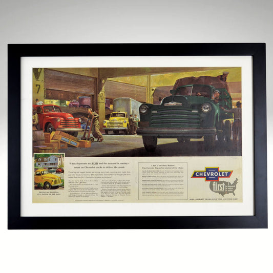 1952 Chevrolet truck framed vintage print featuring classic work trucks in a freight terminal, with original patina, staple marks, and a handwritten "1952" for authenticity.