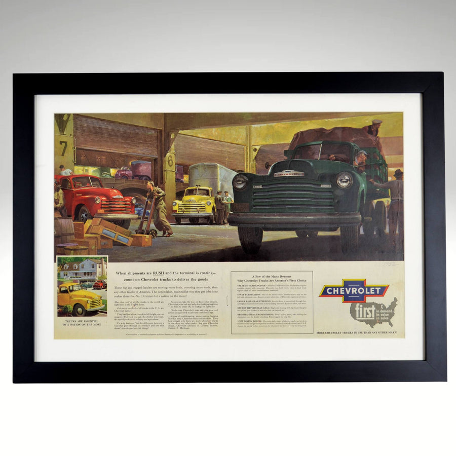 1952 Chevrolet truck framed vintage print featuring classic work trucks in a freight terminal, with original patina, staple marks, and a handwritten "1952" for authenticity.