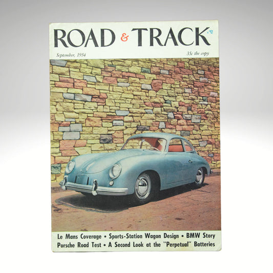 Vintage 'Road & Track' magazine cover with a blue Porsche car against a stone wall.