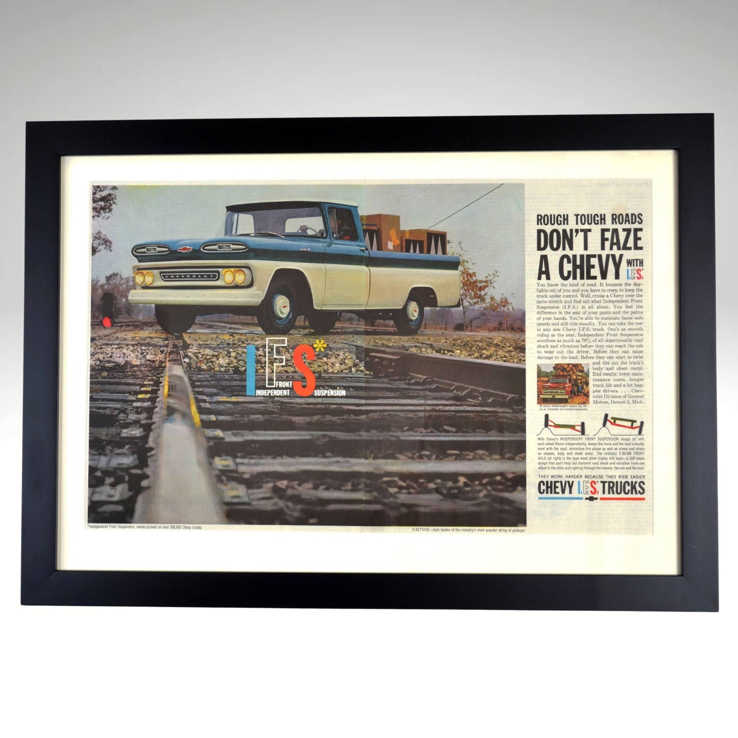 1961 Chevrolet truck framed vintage print featuring a two-tone Chevy pickup conquering railroad tracks, showcasing Independent Front Suspension technology.