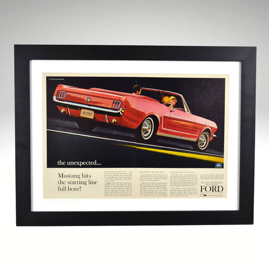 Framed 1964 Ford Mustang convertible print ad showcasing a red Mustang driving with passengers, beautifully framed with a black wood frame and white mat.