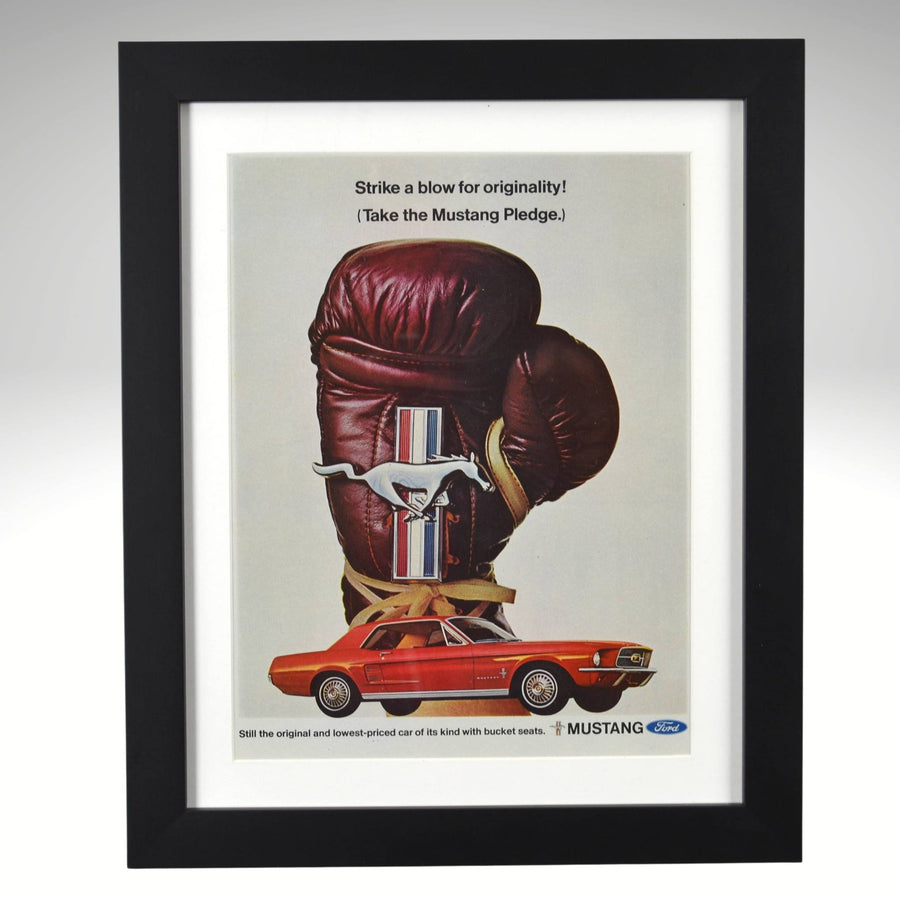 Framed advertisement for 1965 Ford Mustang with boxing glove and car design.