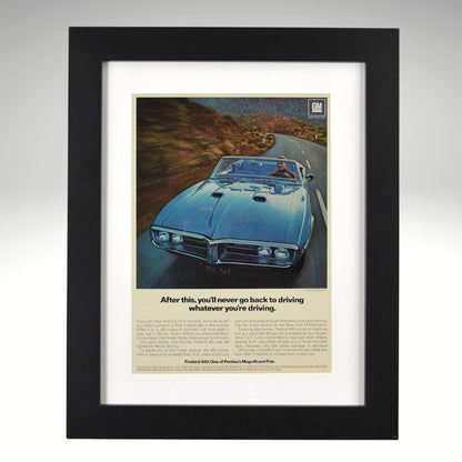 Framed 1967 Pontiac Firebird 400 convertible print ad – vintage GM muscle car wall art with blue Firebird driving on a mountain road.