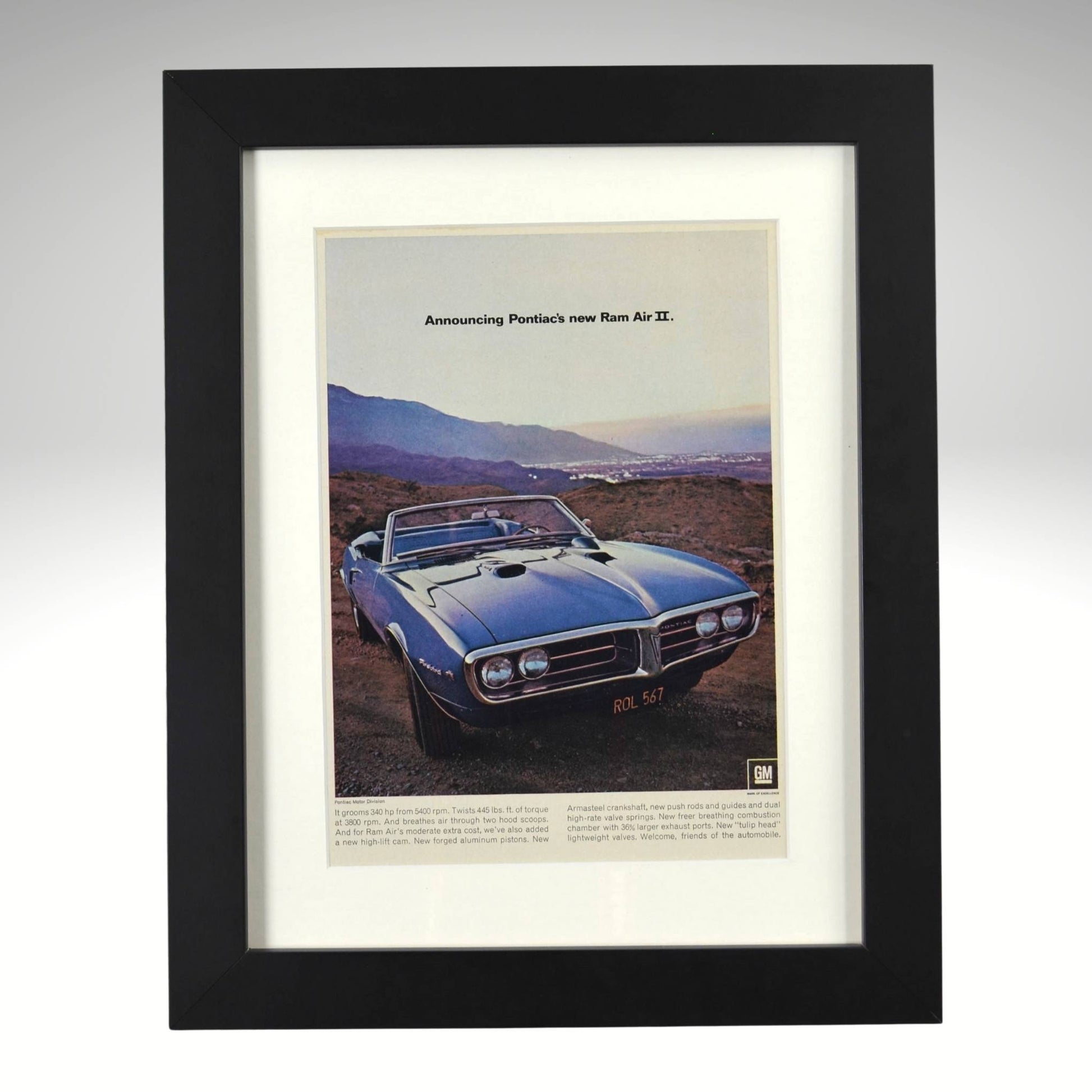 Framed 1967 Pontiac Firebird Ram Air II convertible ad – vintage muscle car print with scenic background and GM performance theme.