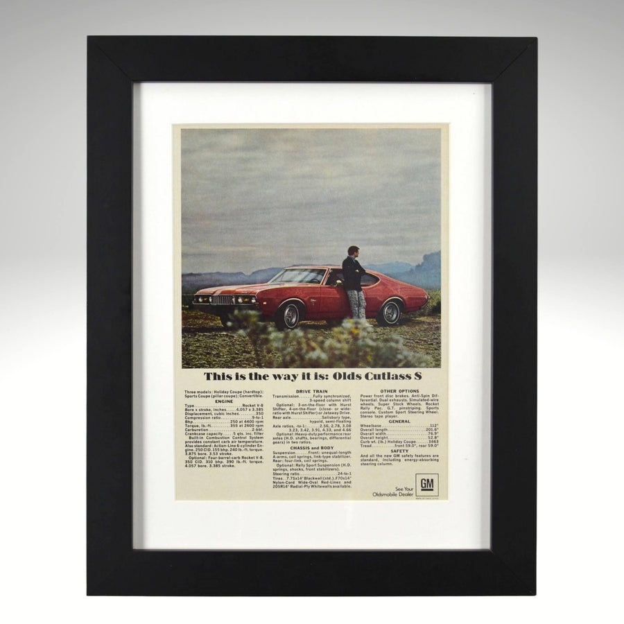 Framed 1968 Oldsmobile Cutlass S ad – red Cutlass in countryside with specs and headline “This is the way it is.”