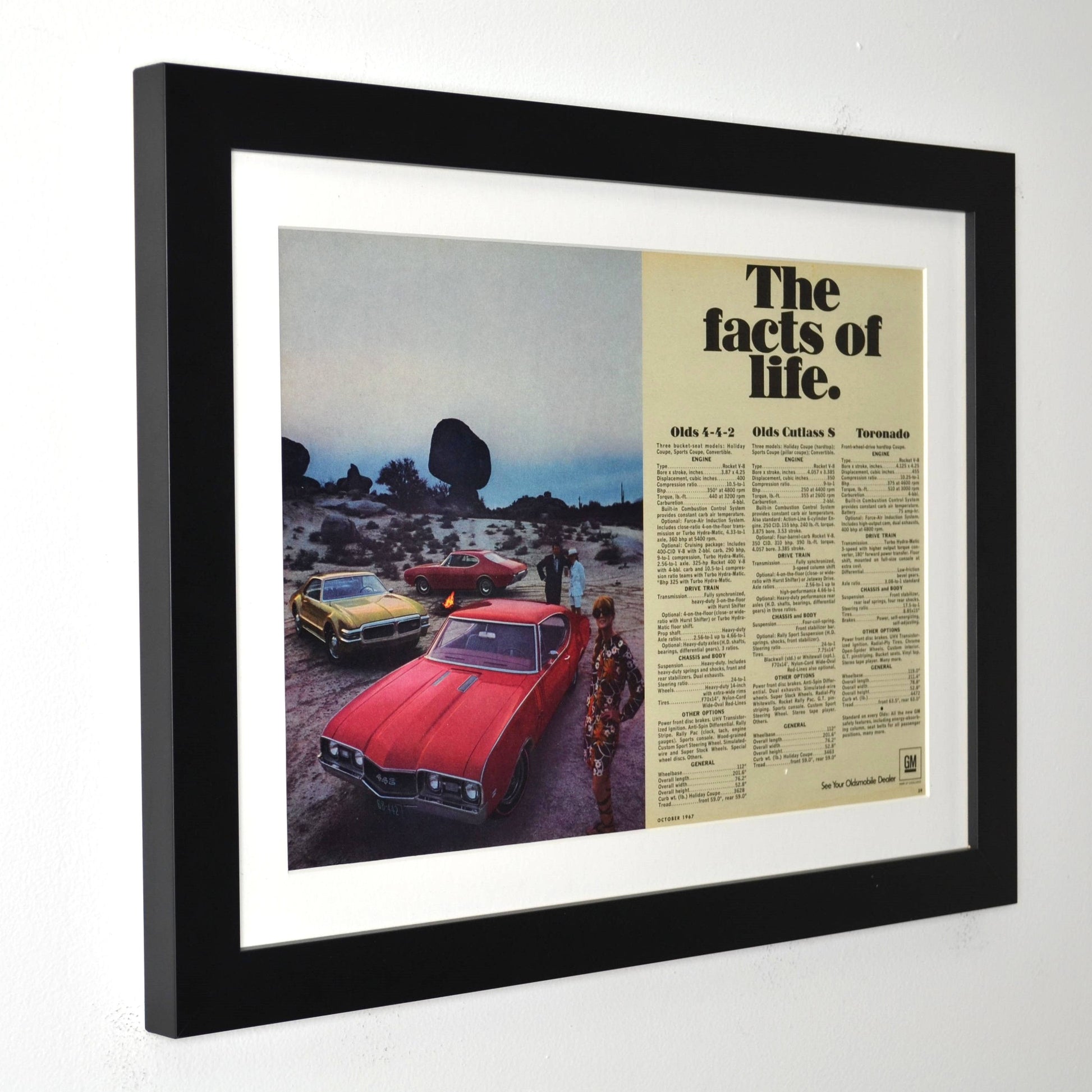 Framed advertisement with vintage Oldsmobile cars and text on a white background
