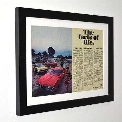 Framed advertisement with vintage Oldsmobile cars and text on a white background