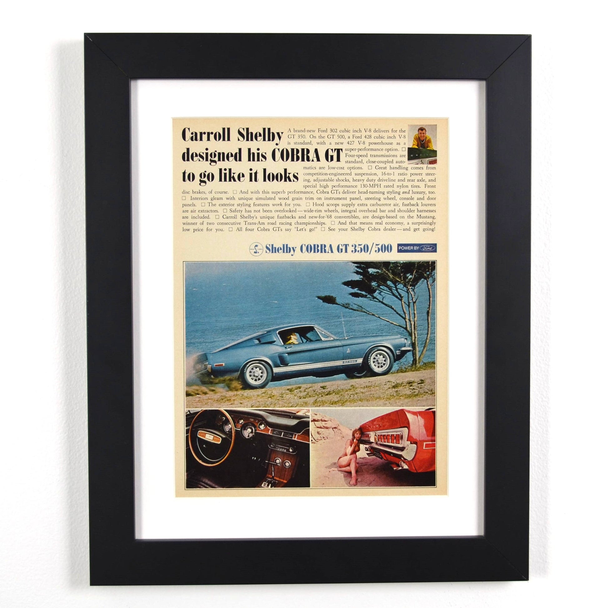 Framed 1968 Shelby Cobra GT-350/500 vintage print ad, featuring the blue fastback Shelby Mustang on a scenic coastal road, perfect for collectors and classic car enthusiasts.