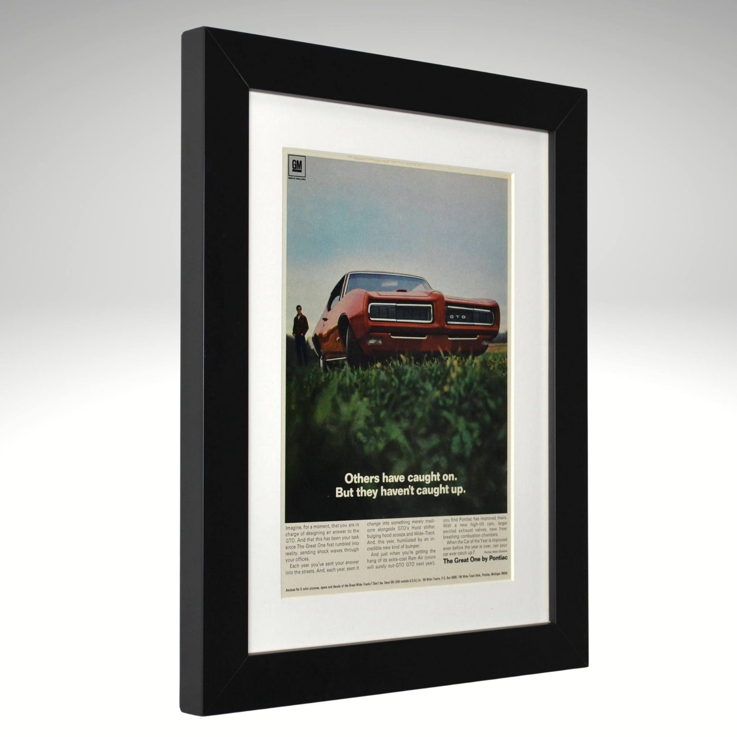 Framed 1968 Pontiac GTO print ad – vintage muscle car art featuring red GTO with hidden headlights and bold low-angle side view.