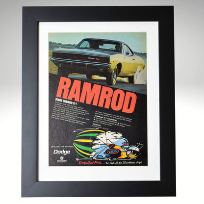 Framed 1969 Dodge Charger R/T “Ramrod” vintage print ad featuring a yellow Charger R/T launching hard with Scat Pack bumblebee logo and bold red lettering — authentic Mopar wall art for collectors.