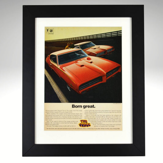 Framed 1969 Pontiac GTO Judge vintage print ad featuring two Carousel Red GTOs with headline “Born Great.” Displayed in a matte black frame with white mat — classic muscle car wall art for collectors and enthusiasts.