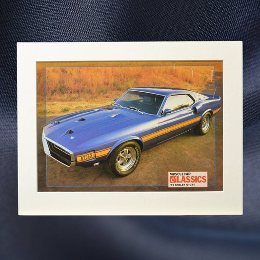 1969 Shelby GT-350 vintage print ad, featuring the bold blue Mustang with gold stripes, an iconic muscle car perfect for collectors and Ford fans.