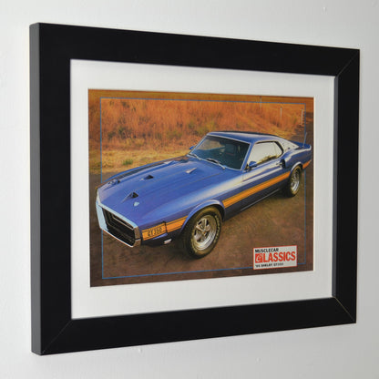 Framed side view of 1969 Shelby GT-350 vintage print ad, featuring the bold blue Mustang with gold stripes, an iconic muscle car perfect for collectors and Ford fans.