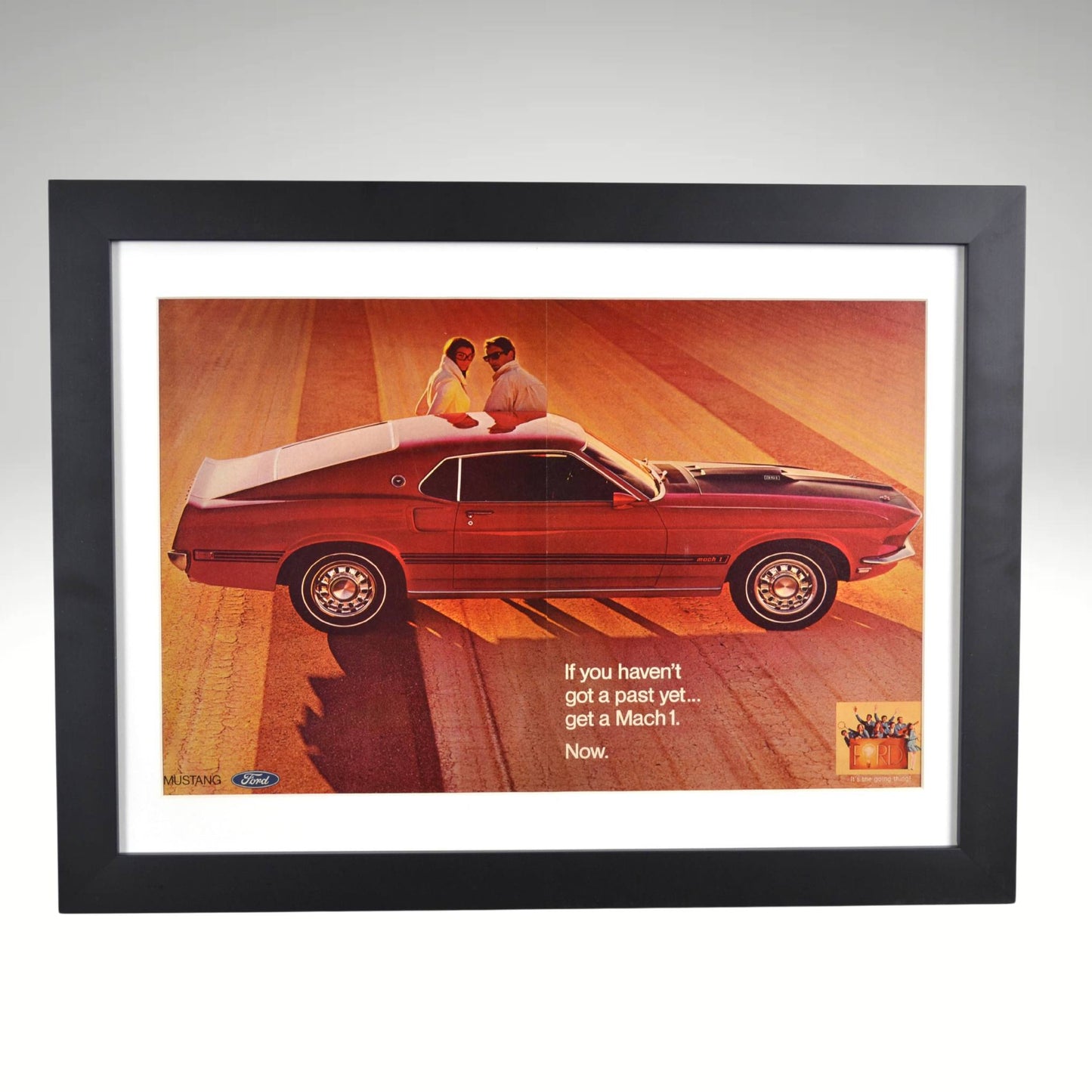 Framed 1969 Ford Mustang Mach 1 vintage print ad featuring bold styling and performance in the golden era of muscle cars.

