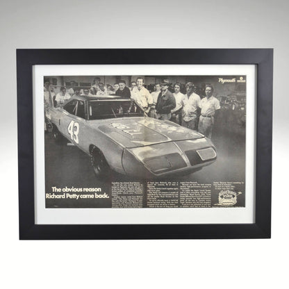 Framed 1970 Richard Petty Plymouth Superbird black and white print featuring the legendary NASCAR driver’s return to Plymouth, displayed in a black frame with glass front.

