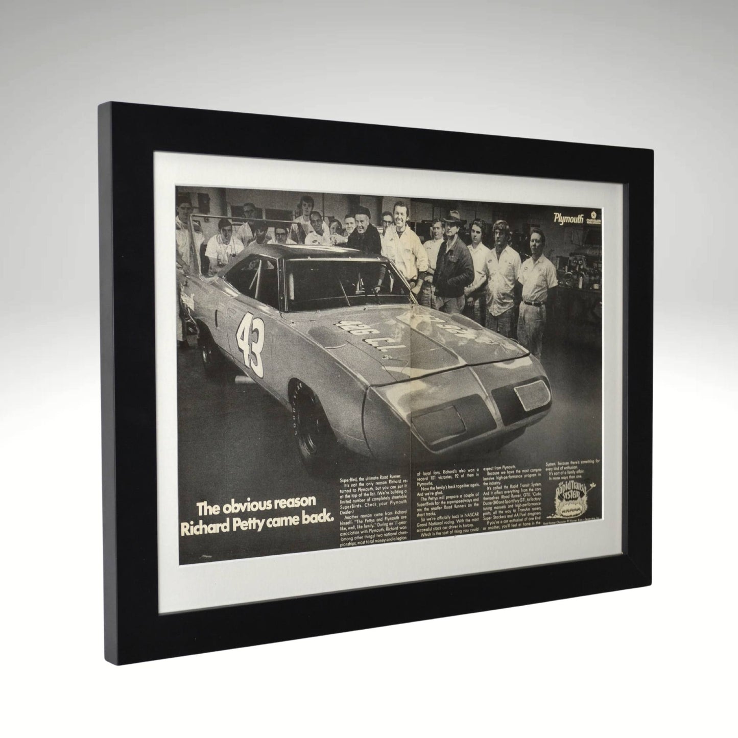 Framed 1970 Richard Petty Plymouth Superbird print featuring the legendary NASCAR driver’s return to Plymouth, displayed in a black frame.

