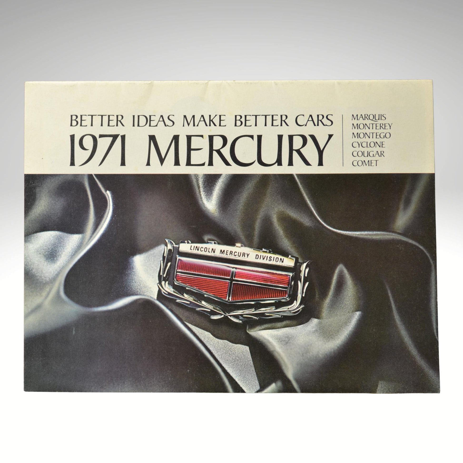 1971 Mercury car brochure cover with logo on a dark fabric background