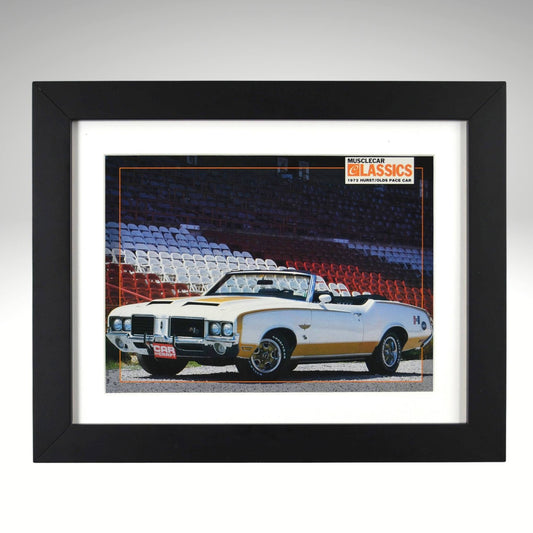 Framed 1972 Hurst/Olds pace car print – white and gold convertible parked at racetrack with grandstands in background.

