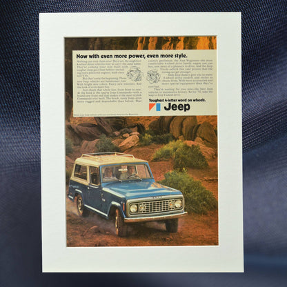 1972 Jeep Commando print ad featuring a blue Jeep navigating rugged terrain. A perfect piece of retro automotive wall art for Jeep enthusiasts.