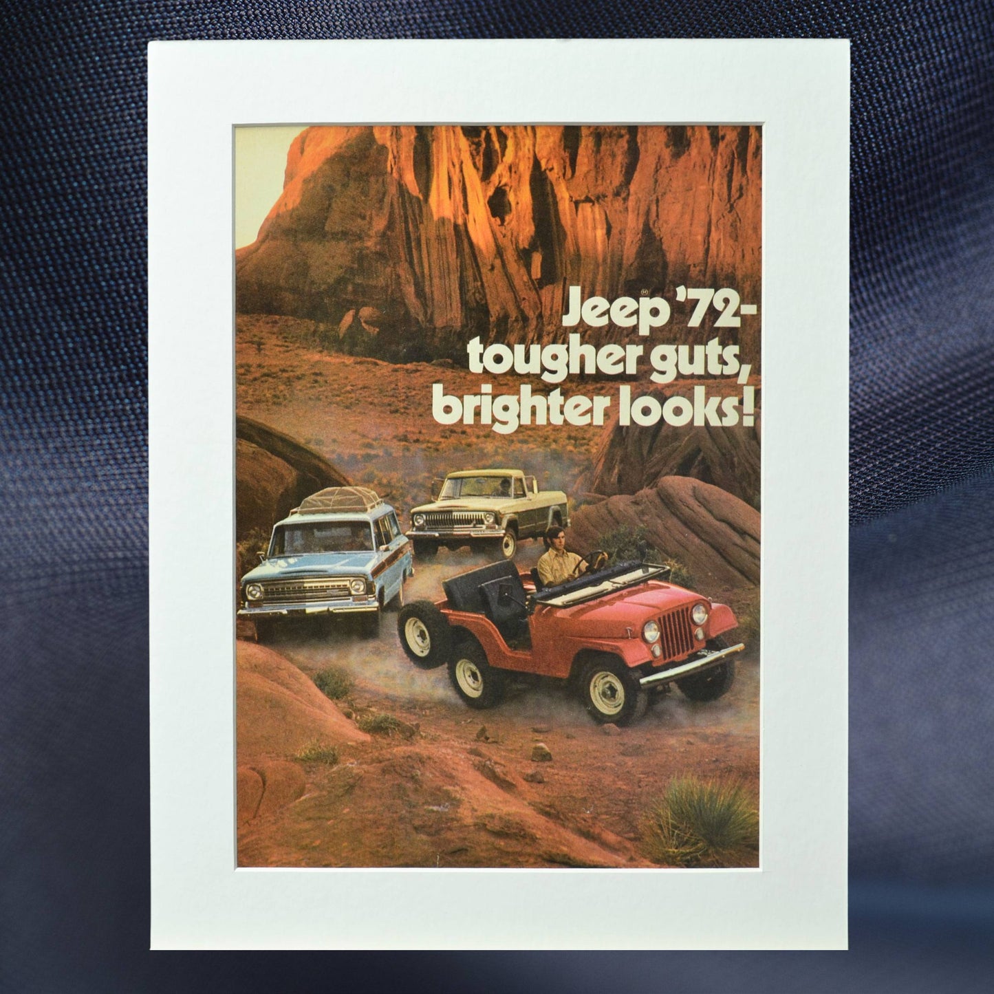 1972 Jeep vintage print ad featuring a Jeep CJ, Wagoneer, and Jeep Gladiator driving through rugged terrain. Perfect retro car poster for collectors and Jeep enthusiasts.