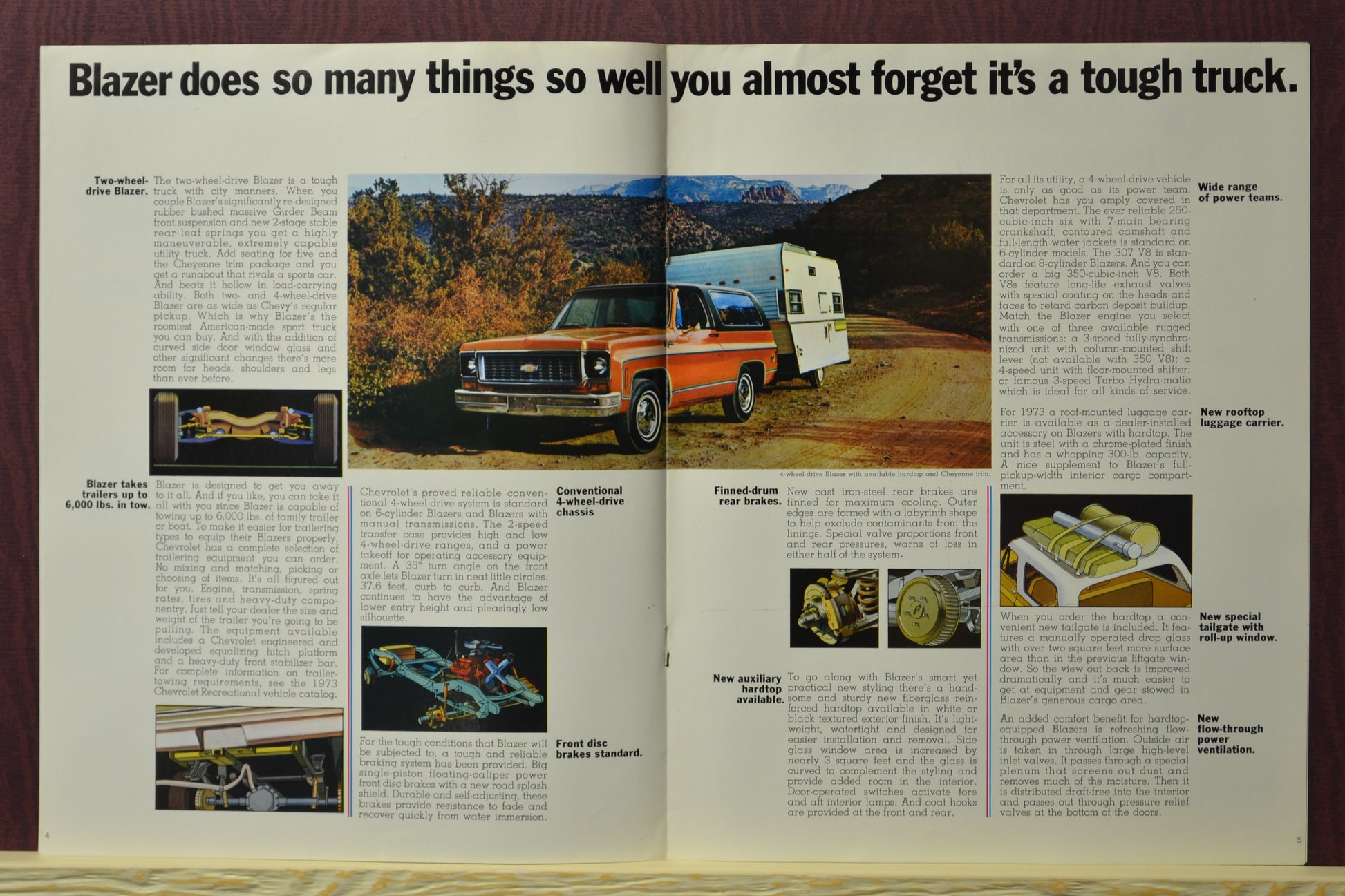 1973 Chevy Blazer brochure showcasing Blazer’s versatility with a red Blazer towing a trailer on a gravel road in the mountains