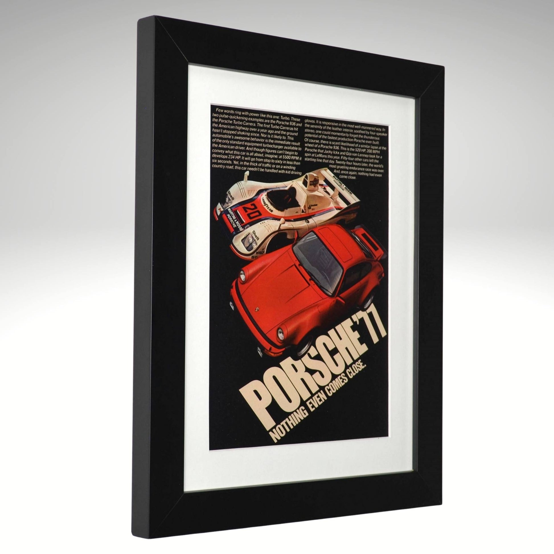 Framed 1977 Porsche Turbo vintage print ad featuring a red 911 Turbo and Porsche 936 race car with bold text reading “Nothing Even Comes Close.” Displayed in a matte black frame with white mat—perfect automotive wall art for collectors side view